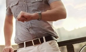 homem com camisa de manga curta olhando relogio