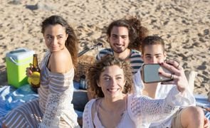 pessoas tirando foto na praia